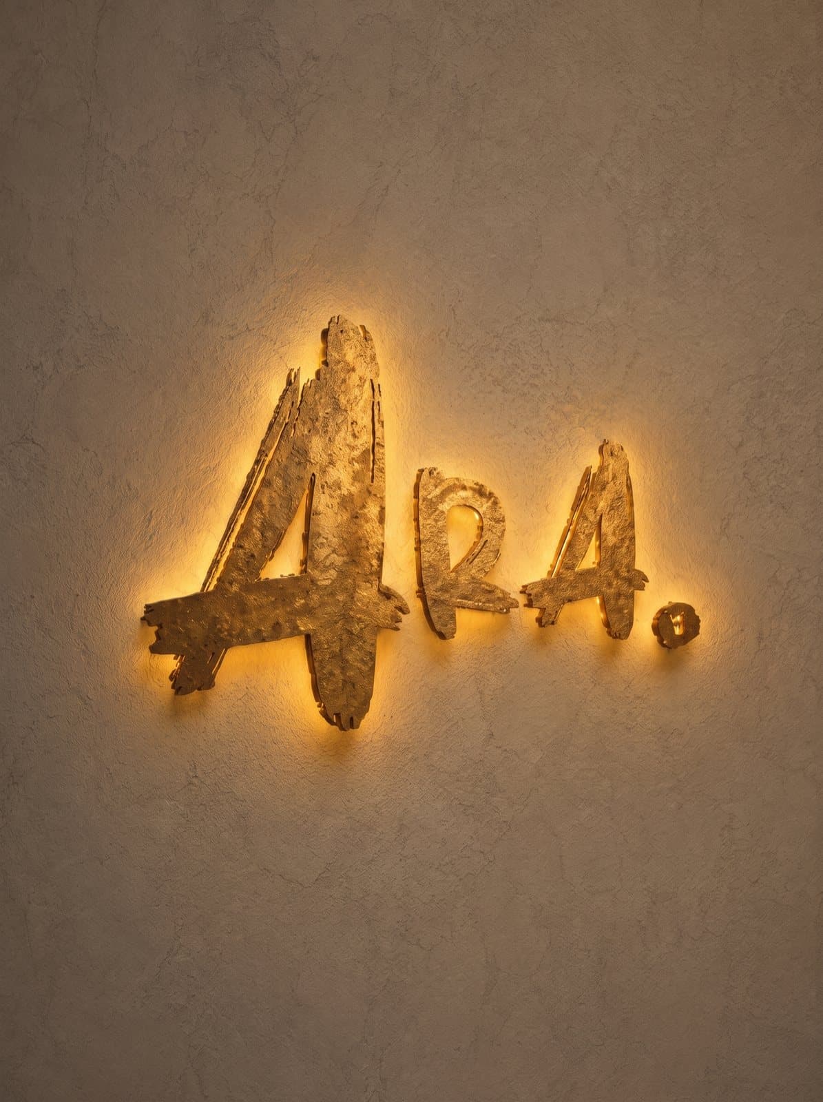 Rótulo dorado de ARA. retroiluminado sobre la pared