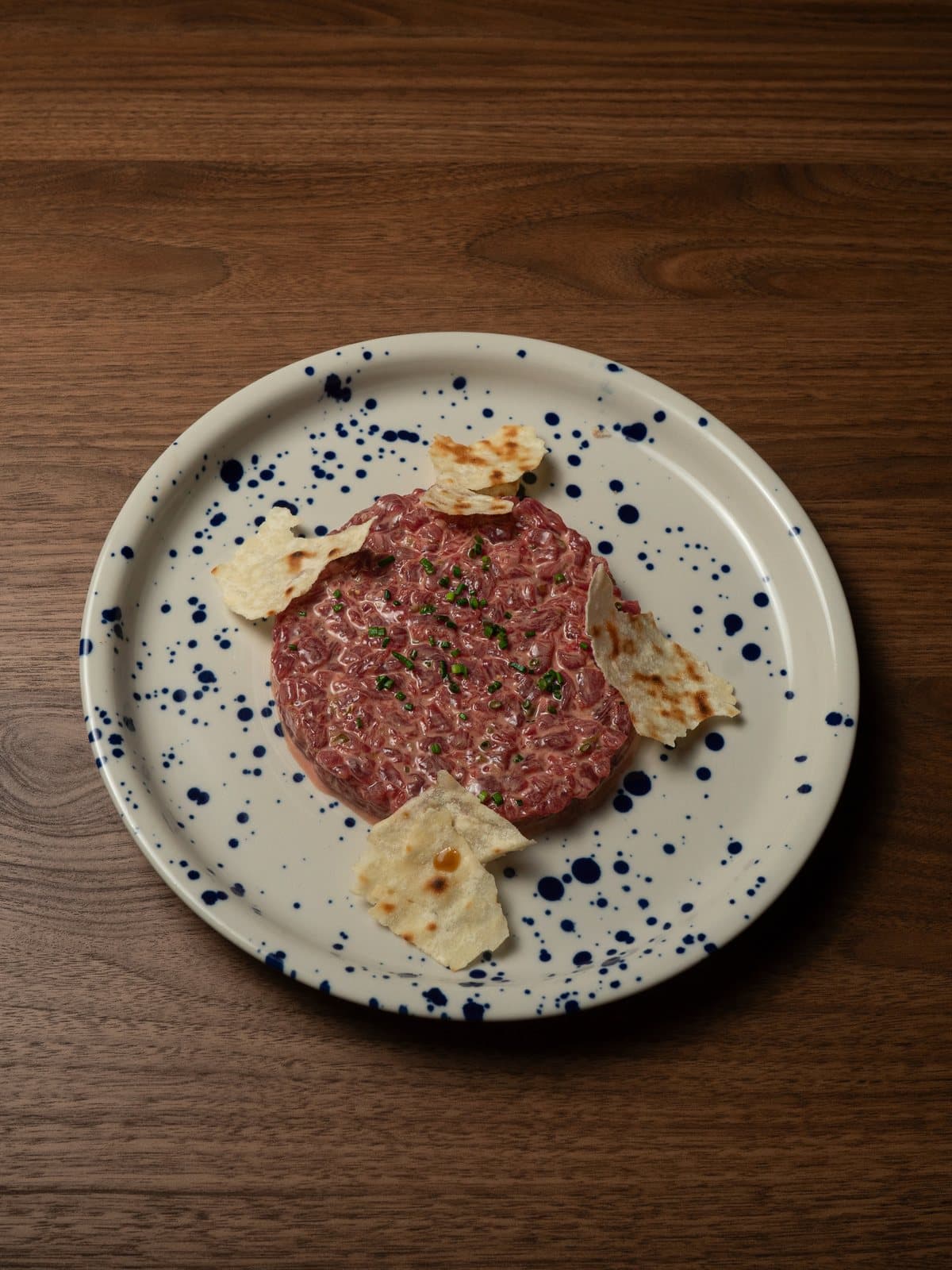 Steak tartar servido en plato de cerámica moteada